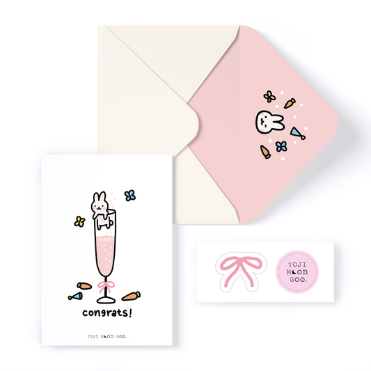 A pink envelope containing a card and a decorative sticker, elegantly arranged for a special occasion.